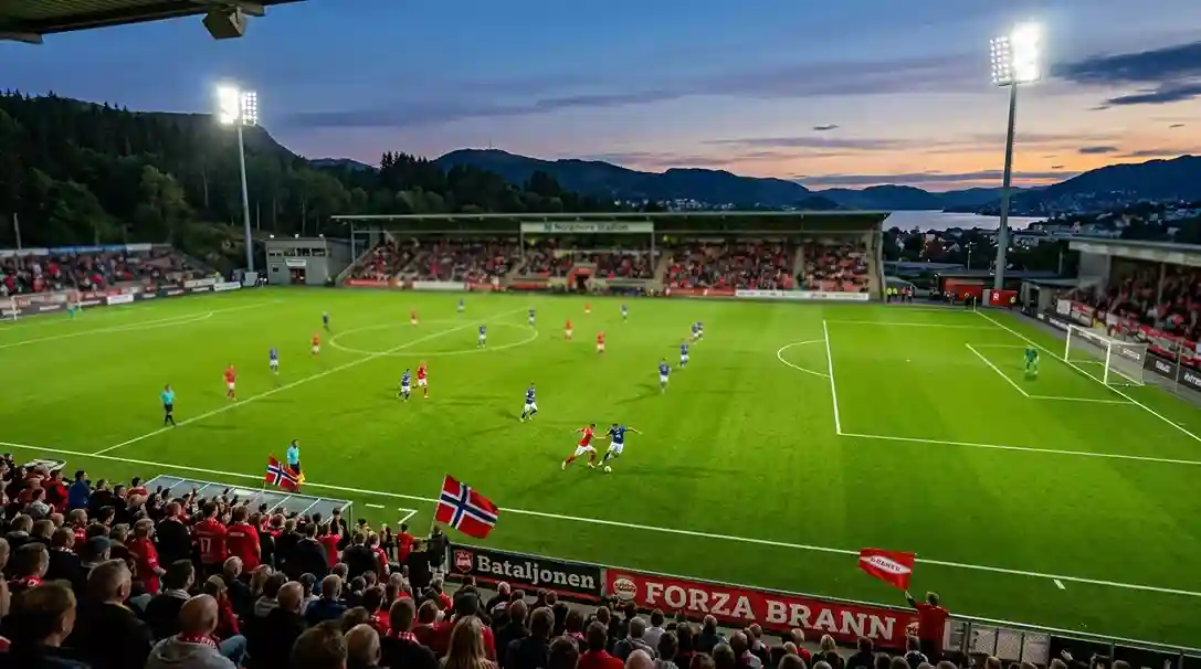 Fotballkamp på en norsk stadion med gress, tribune og flomlys